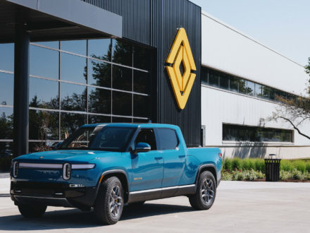 An R1T in Rivian Blue at the main entrance to the plant in Normal, IL.